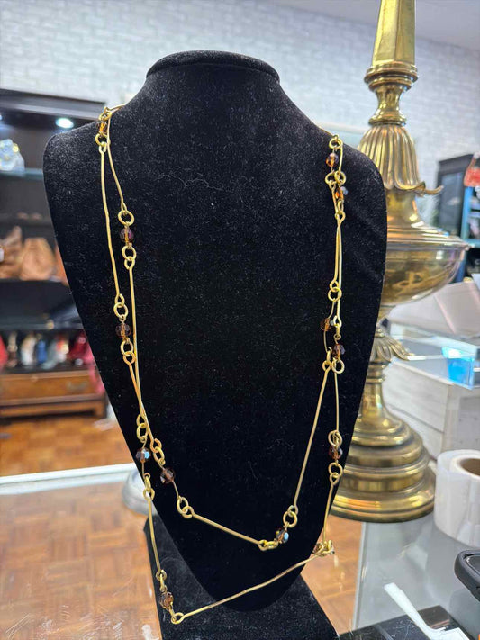 Gold necklace with brown beads and long